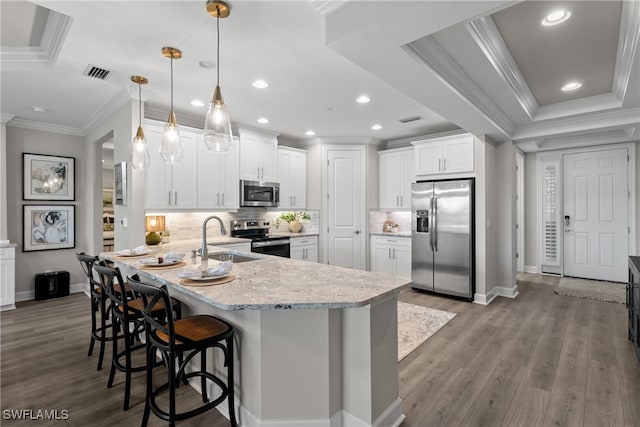 kitchen with white cabinetry, sink, stainless steel appliances, kitchen peninsula, and pendant lighting