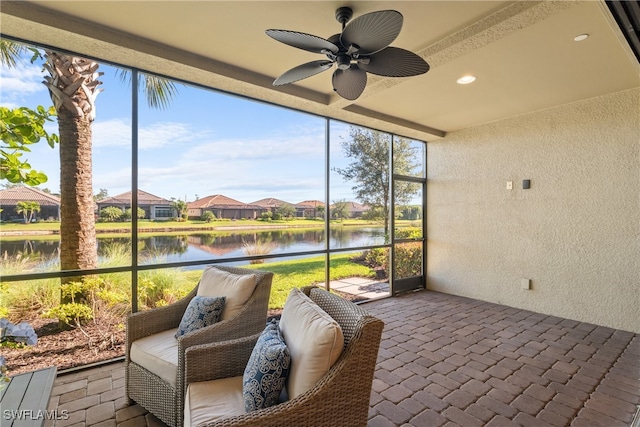 sunroom / solarium featuring ceiling fan, plenty of natural light, and a water view