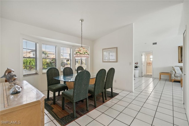 dining room with lofted ceiling and light tile patterned floors