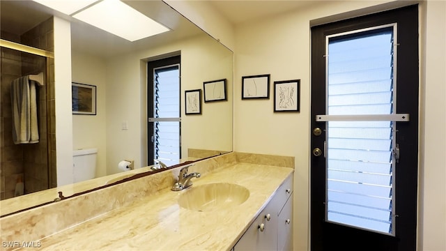 bathroom with vanity, toilet, and a shower with shower door