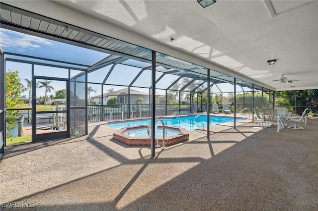 view of swimming pool with ceiling fan, a lanai, an in ground hot tub, and a patio