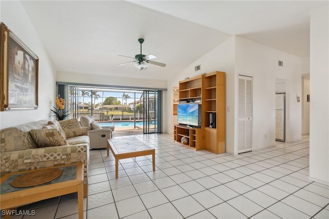 living room featuring ceiling fan, light tile patterned flooring, and vaulted ceiling