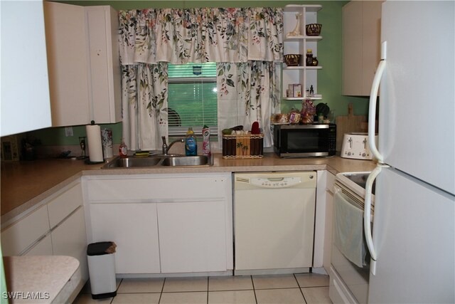 kitchen with white cabinets, white appliances, light tile patterned flooring, and sink