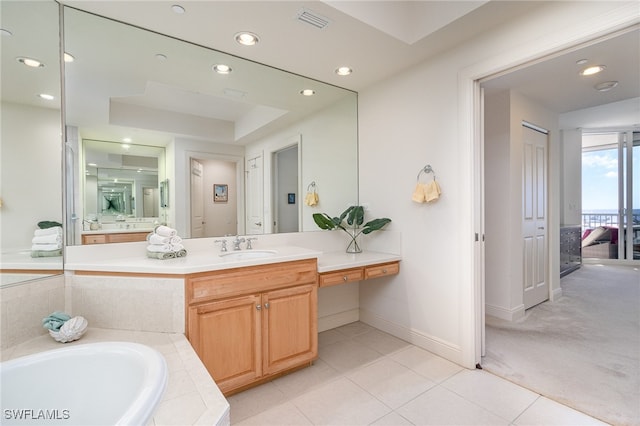 bathroom featuring tile patterned flooring, vanity, and a relaxing tiled tub