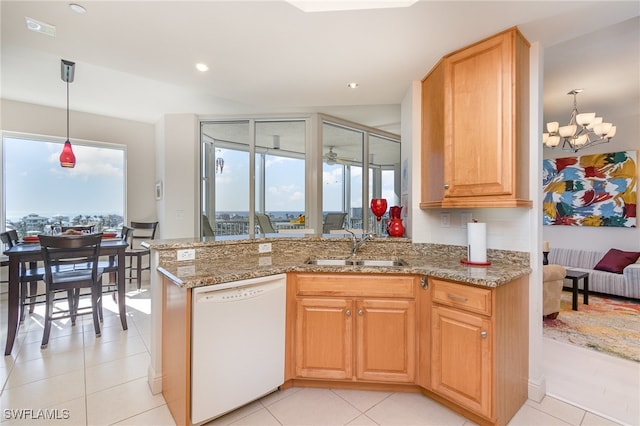 kitchen with pendant lighting, dishwasher, sink, a notable chandelier, and light stone counters