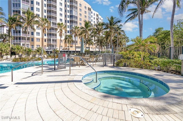 view of pool with a patio area and a hot tub