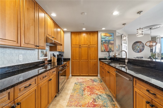 kitchen featuring sink, hanging light fixtures, backsplash, dark stone counters, and appliances with stainless steel finishes