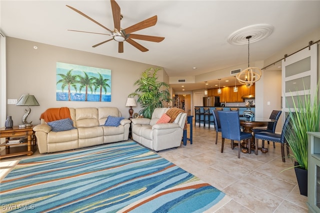 tiled living room with a barn door and ceiling fan