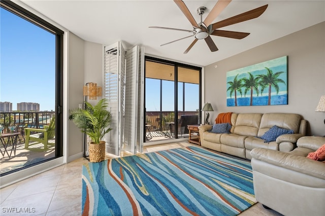 living room featuring ceiling fan, a wall of windows, and light tile patterned floors