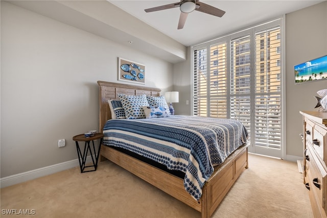 carpeted bedroom featuring multiple windows and ceiling fan