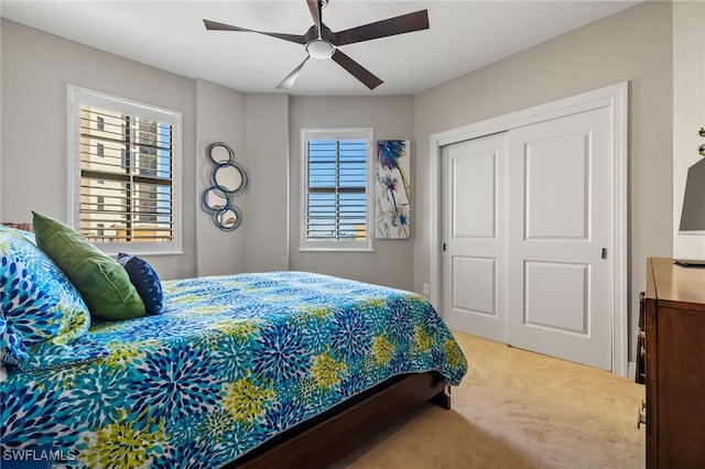 bedroom featuring ceiling fan, a closet, and carpet