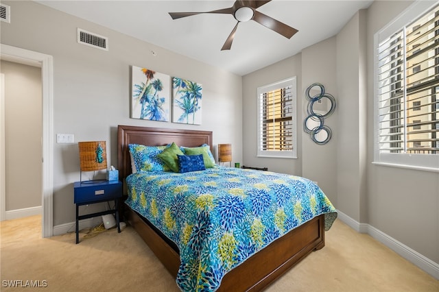 bedroom with carpet, ceiling fan, and multiple windows