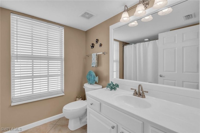 bathroom with toilet, vanity, and tile patterned floors