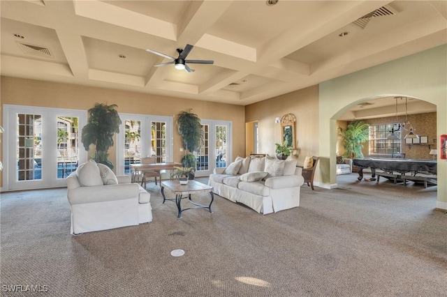 carpeted living room with coffered ceiling, ceiling fan, a healthy amount of sunlight, and french doors