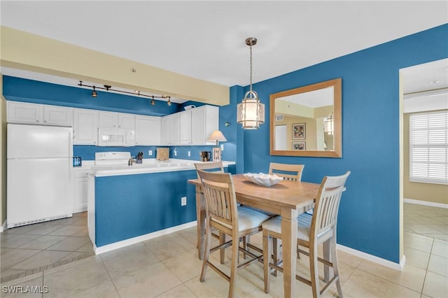 dining space featuring track lighting and light tile patterned flooring