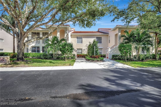 mediterranean / spanish house featuring a front lawn