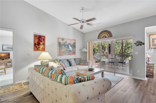 living room featuring ceiling fan, vaulted ceiling, and wood-type flooring