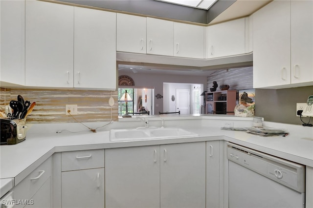 kitchen featuring white dishwasher, white cabinets, tasteful backsplash, and sink