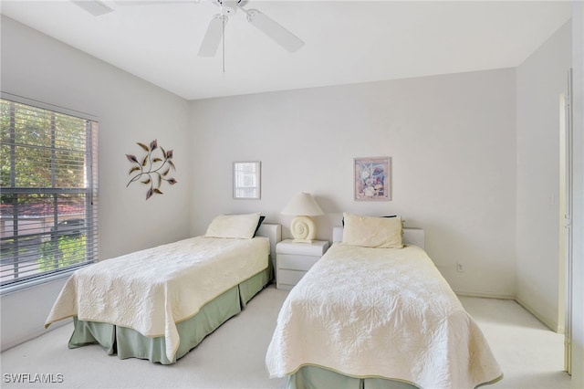 carpeted bedroom with ceiling fan and multiple windows