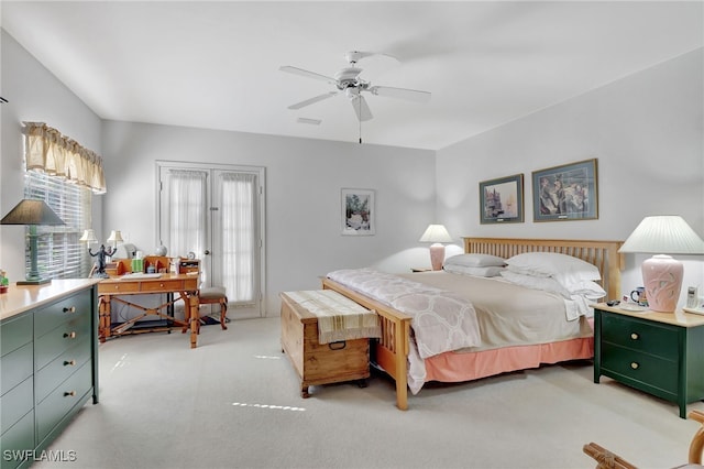 bedroom featuring ceiling fan, light carpet, and french doors