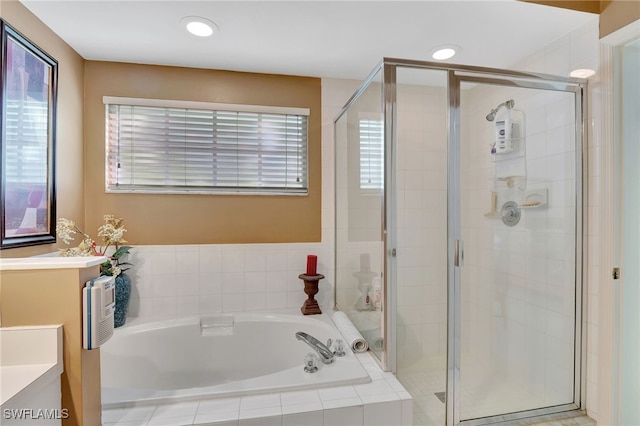 bathroom featuring vanity, independent shower and bath, and a healthy amount of sunlight