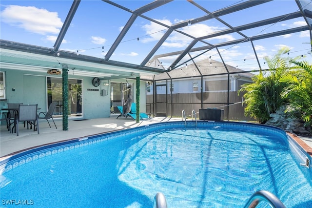 view of swimming pool with glass enclosure and a patio area