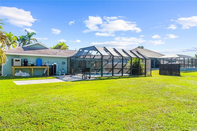 rear view of house with a lanai, a yard, and a bar