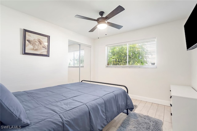 bedroom featuring ceiling fan, a closet, and light wood-type flooring