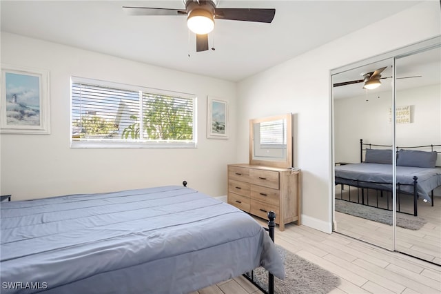 bedroom with ceiling fan, a closet, and light hardwood / wood-style floors