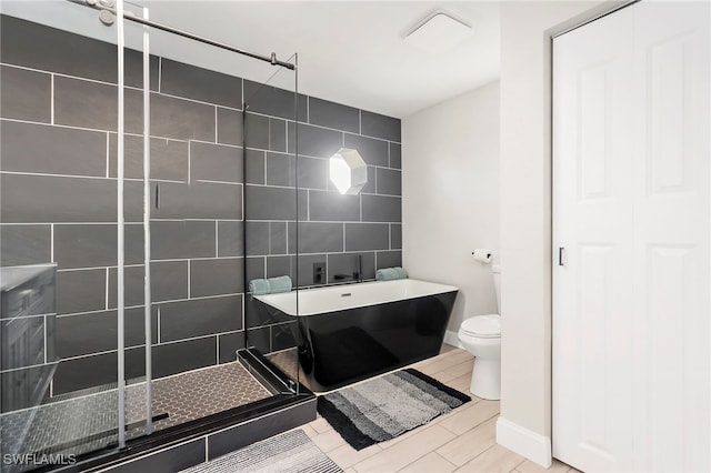 bathroom featuring plus walk in shower, tile patterned flooring, and toilet