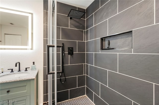 bathroom featuring vanity and tiled shower