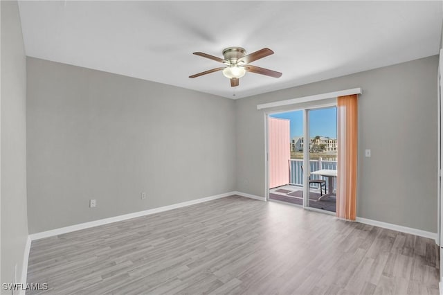 unfurnished room with a ceiling fan, light wood-style flooring, and baseboards