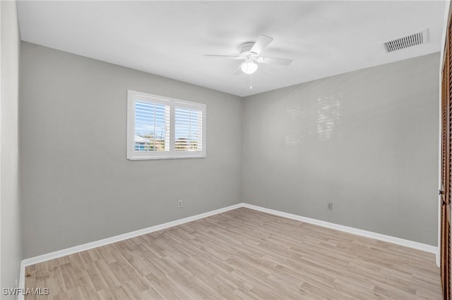 empty room with baseboards, a ceiling fan, visible vents, and light wood-style floors