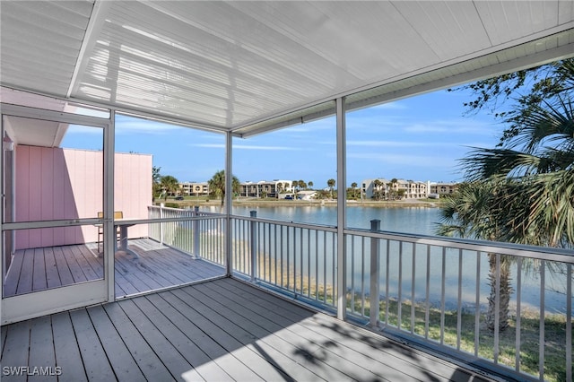 unfurnished sunroom featuring a water view