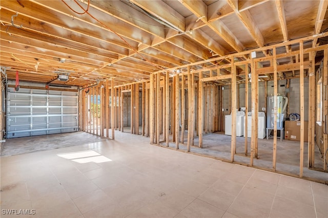 interior space with a garage, water heater, and washer and clothes dryer