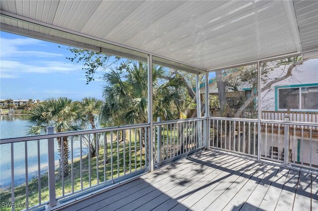 unfurnished sunroom with a wealth of natural light and a water view