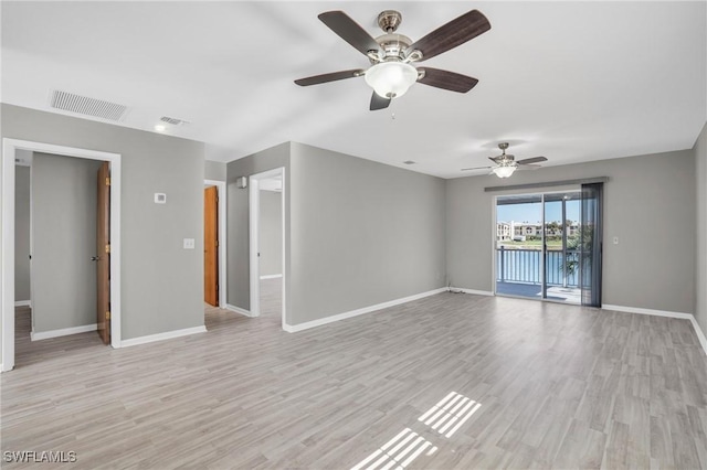 empty room featuring visible vents, light wood-style flooring, and baseboards