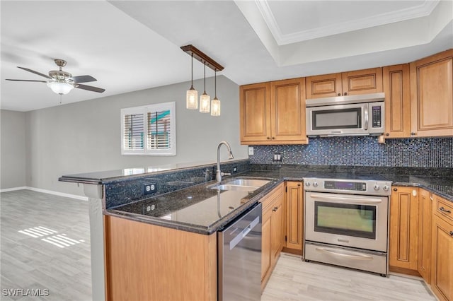 kitchen with light wood-type flooring, kitchen peninsula, sink, and appliances with stainless steel finishes