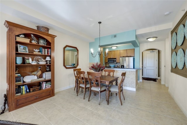 dining space with light tile patterned floors and a chandelier