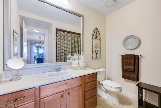 bathroom featuring tile patterned flooring, vanity, an inviting chandelier, and toilet