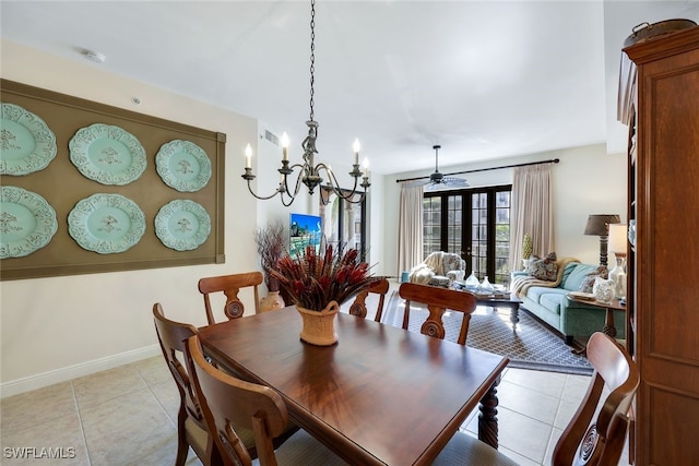 dining area with ceiling fan with notable chandelier, light tile patterned flooring, and french doors