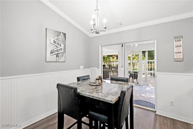 dining area with dark hardwood / wood-style flooring, ornamental molding, and a notable chandelier