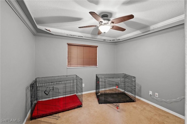 bedroom featuring ceiling fan, a raised ceiling, crown molding, a textured ceiling, and carpet