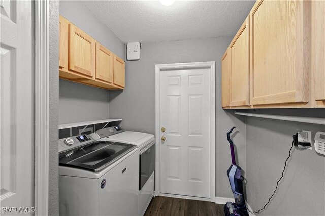 clothes washing area with a textured ceiling, cabinets, dark hardwood / wood-style floors, and independent washer and dryer