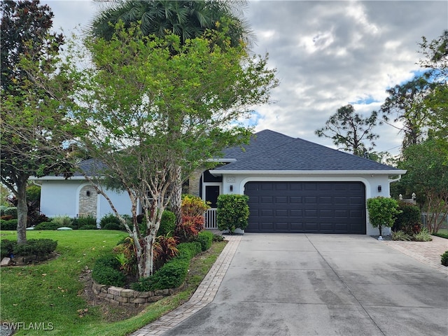 ranch-style house featuring a garage and a front lawn