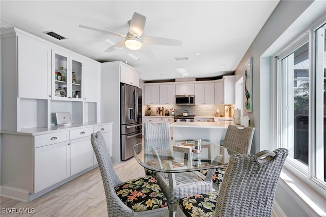 dining room featuring ceiling fan, light hardwood / wood-style flooring, and sink