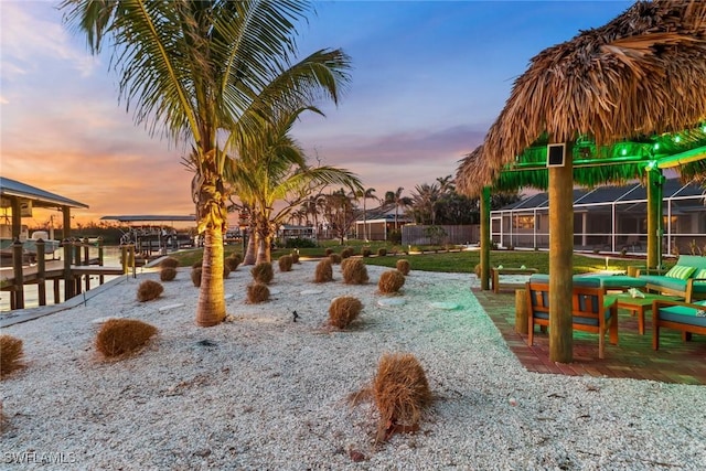 yard at dusk with glass enclosure and a water view