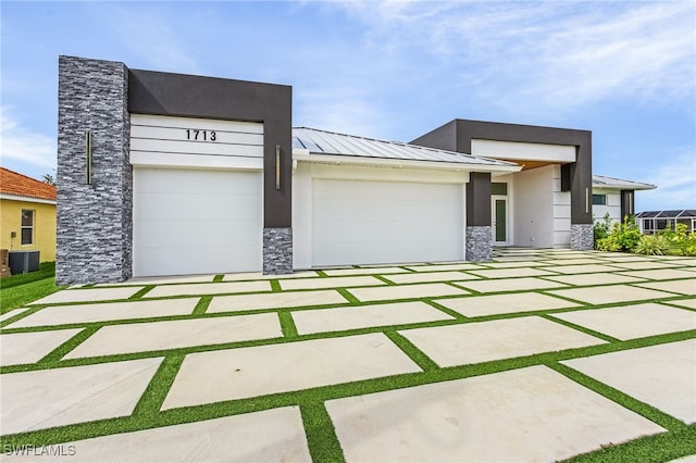 view of front of house featuring central AC and a garage