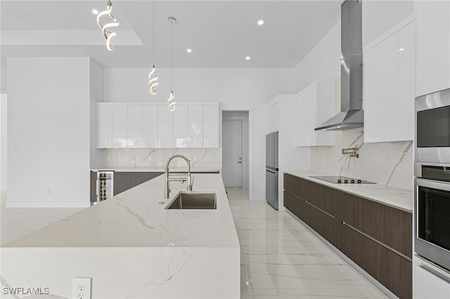 kitchen with dark brown cabinetry, white cabinetry, wall chimney exhaust hood, and decorative light fixtures