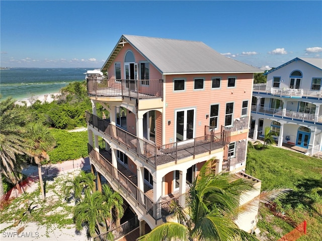 rear view of property featuring a view of the beach and a water view